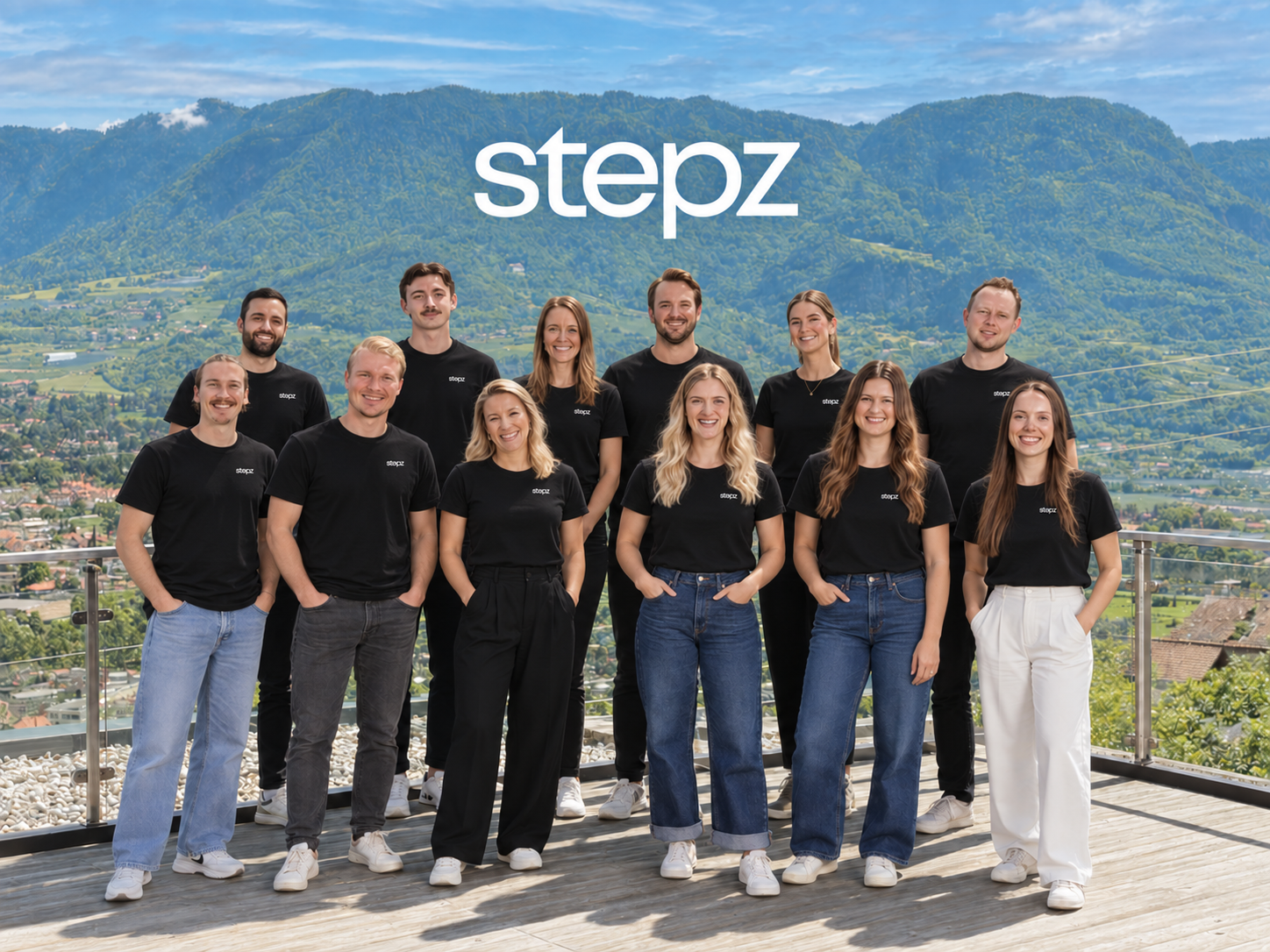 stepz-teamet i svarte stepz-T-skjorter på en terrasse med fjellutsikt